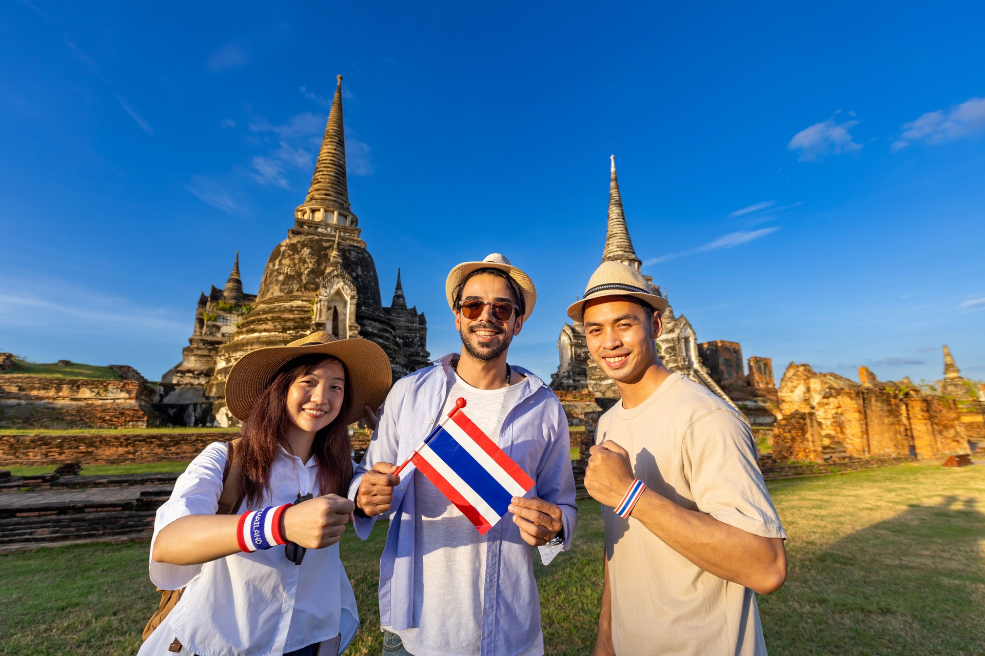 Group of tourist on their backpacker with Thai flag are traveling to ancient temple of Phra Si Sanphet temple, Ayutthaya, Thailand for tourism and sightseeing